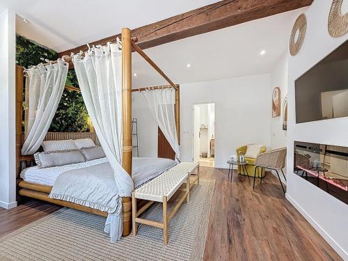 Cottages Occitans في Villepinte: غرفة نوم بها سرير ذو مظلة وطاولة