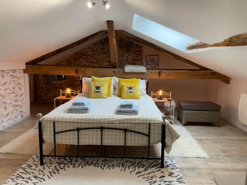 a bedroom with a bed with yellow pillows at Lime Tree Farmhouse in Saint-Saud-Lacoussière