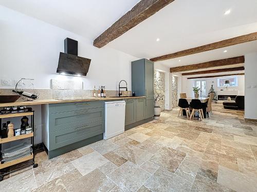 Cottages Occitans في Villepinte: مطبخ مع خزائن خضراء وغرفة طعام