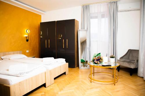 una camera d'albergo con due letti e un tavolo di Random House a Braşov