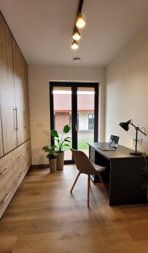 an office with a desk and a chair with a laptop at Eko Osada Zacisze in Ostrowite