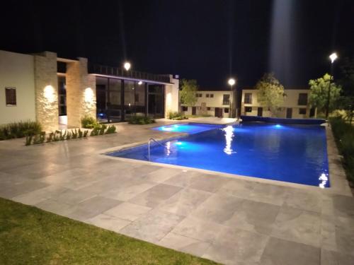 ein Schwimmbad in der Nacht vor einem Gebäude in der Unterkunft House B Residential condominium with pool in Miranda