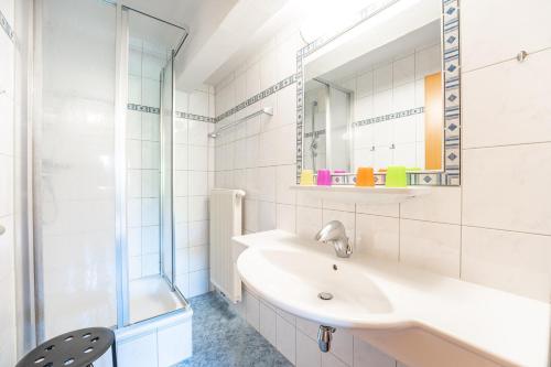 a white bathroom with a sink and a shower at Apartment Mauser-Mühltaler in Mauterndorf