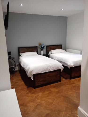 two beds in a room with wooden floors at Number 5 in Harwich