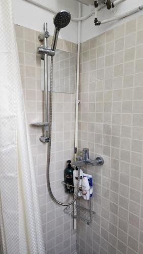 a shower with a shower head in a bathroom at Huge Studio and Rooftop in Central in Hong Kong