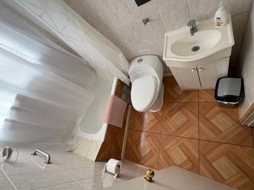 een kleine badkamer met een wastafel en een toilet bij Departamento tranquilo y equipado en parcela privada, cerca de comercios in Puerto Montt