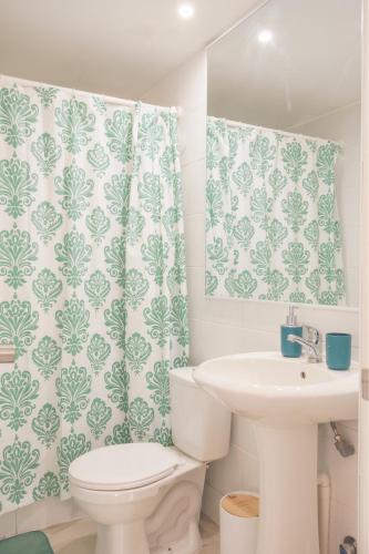 a bathroom with a toilet and a sink at Departamento Sol in El Tabo