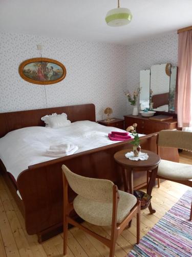 una camera da letto con un letto, una sedia e un tavolo di Kleine Auszeit für nette Leute a Grebenhain