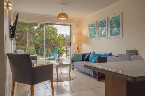 een woonkamer met een bank en een tafel bij Departamento Sol in El Tabo