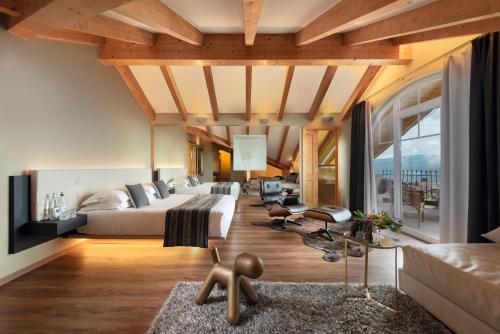 een slaapkamer met een groot bed en een woonkamer bij Alp Wellness Sport Hotel Panorama in Fai della Paganella