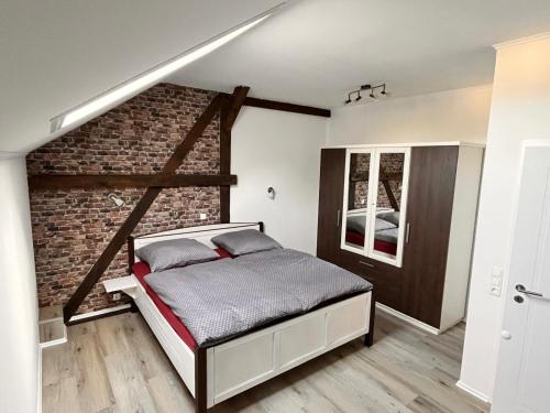 a bedroom with a bed and a brick wall at Seeidyll Potzlower See in Potzlow