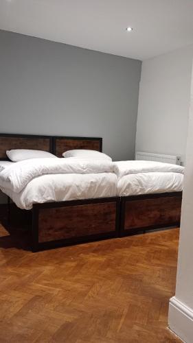 two beds in a room with wooden floors at Number 5 in Harwich
