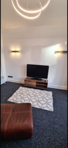 a living room with a couch and a flat screen tv at The Victorian Terrace in Morecambe