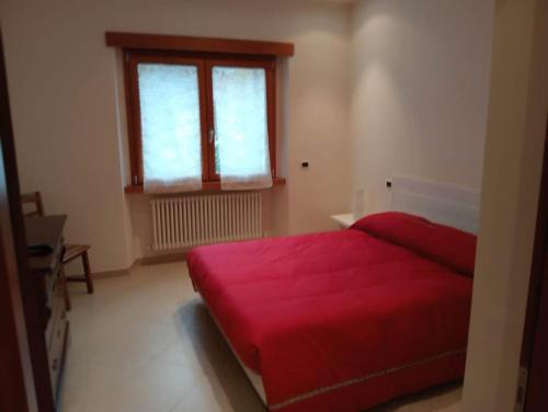 a bedroom with a red bed and a window at Casa Vacanze Giano in Antrodoco