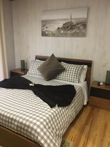 a bed with black and white sheets and pillows at Chalé de Montanha in Vieira do Minho