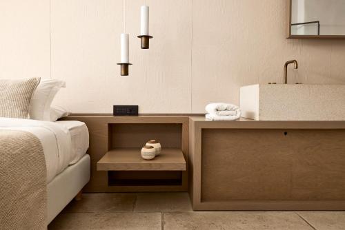 a bedroom with a bed and a sink and a table at Hotel Adonis in Mýkonos City