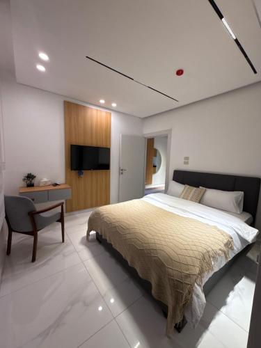 ein Schlafzimmer mit einem Bett, einem Schreibtisch und einem Fernseher in der Unterkunft Riva suites in Irbid