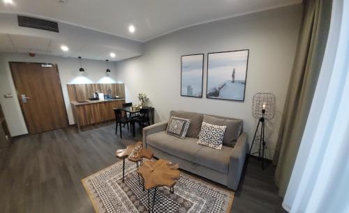 a living room with a couch and a table at Apart Hill in Sosnówka