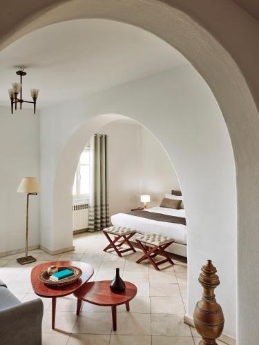 un salon avec un lit et une table dans l'établissement Hotel Adonis, à Mykonos