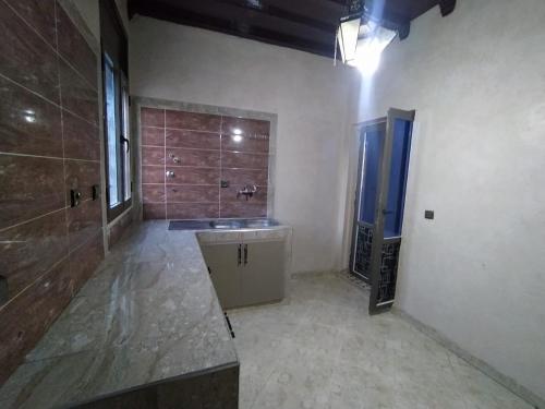 a large bathroom with a sink and a shower at Camels house apartment in Adrouine