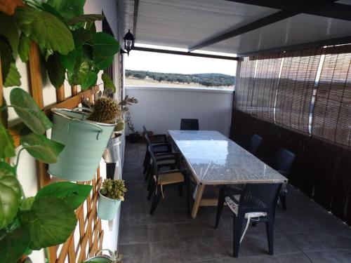 a patio with a table and chairs on a balcony at Casa rural El Candil in Olivenza
