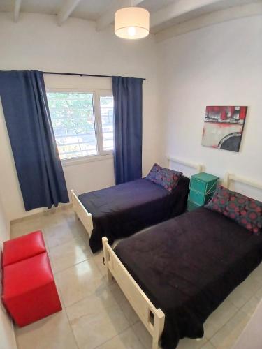 a bedroom with two beds and a window at Casa Parque Playa in Necochea