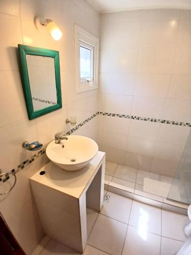 a bathroom with a sink and a shower and a mirror at Casa Parque Playa in Necochea