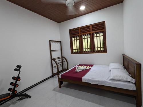 a bedroom with a bed and a window at Villa 505 Induruwa in Induruwa