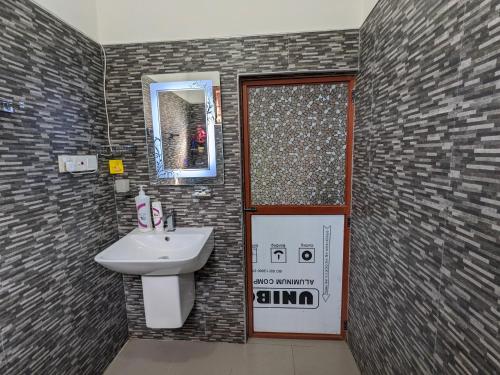 a bathroom with a sink and a mirror and a door at Villa 505 Induruwa in Induruwa
