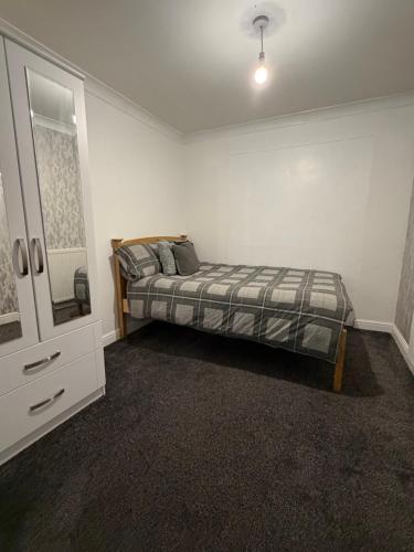 a bedroom with a bed and a dresser in it at Nightingale Roomz in Lower Darwen