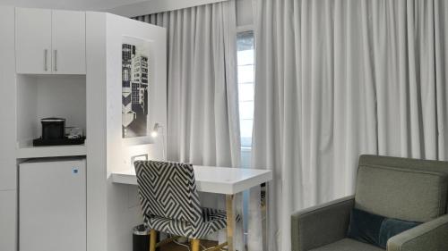 ein Zimmer mit einem Schreibtisch und einem Stuhl und einem Fenster in der Unterkunft MetLife Stadium Hotel for Matchdays Game Shuttle in Secaucus