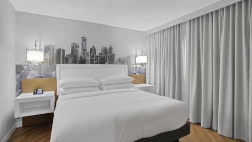 ein Schlafzimmer mit einem großen weißen Bett und einem Fenster in der Unterkunft MetLife Stadium Hotel for Matchdays Game Shuttle in Secaucus