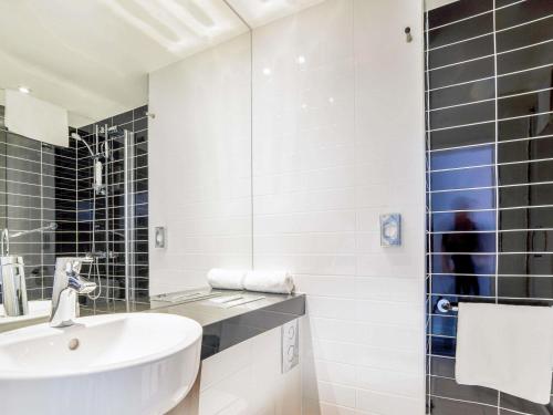 een witte badkamer met een wastafel en een douche bij ibis Styles Wałbrzych in Wałbrzych