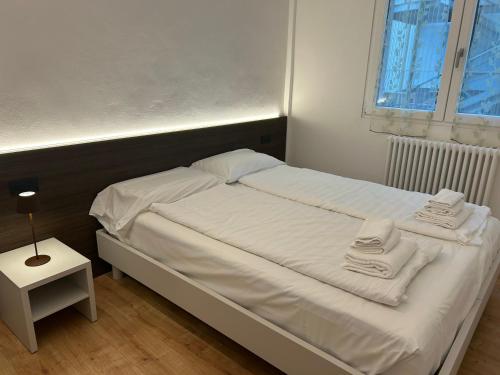 a white bed with towels on it in a bedroom at Colombo Central Apartment in Garda