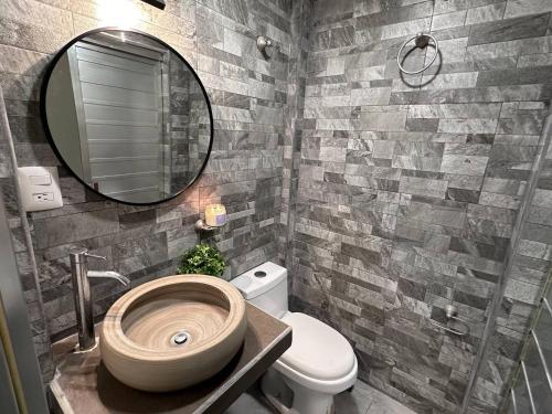 a bathroom with a sink and a toilet and a mirror at Steps from the Historic Center & Malecón in Campeche