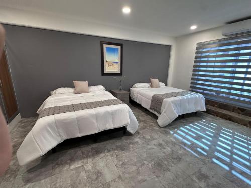 a bedroom with two beds and a window at Steps from the Historic Center & Malecón in Campeche
