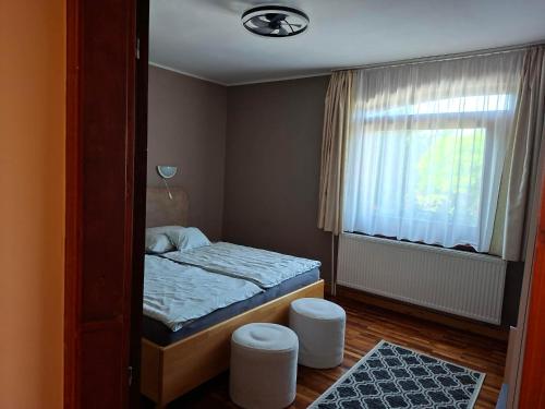 una piccola camera da letto con un letto e una finestra di SUNFISH Apartman a Balatonszárszó