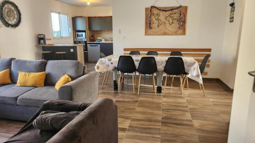 a living room with a table and chairs and a couch at Maison proche Futuroscope in Chasseneuil-du-Poitou