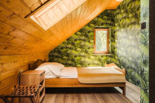 a bedroom with a bed in a room with green wallpaper at Agroturystyka Monte Luna - Domki in Czarnów