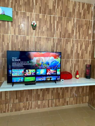 een flatscreen-tv zittend op een plank bij Green House Cumbuco in Caucaia