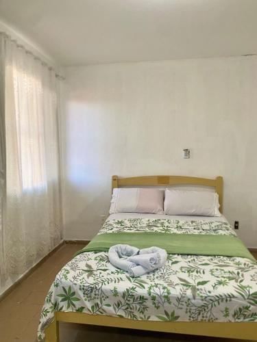 een slaapkamer met een bed met een handdoek erop bij Green House Cumbuco in Caucaia