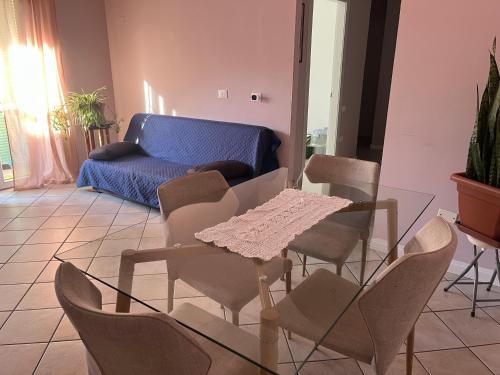een woonkamer met een tafel, stoelen en een bank bij Emy House in Azzano San Paolo