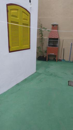 Zimmer mit grünem Boden und gelber Tür in der Unterkunft Casa para alugar in Paraty