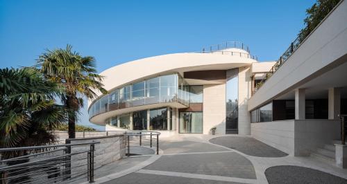 a large building with a glass facade and palm trees at CONTiNUUM in Ulcinj
