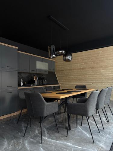 una cucina con tavolo e sedie in legno di Black Chalet 2 a Vârtop