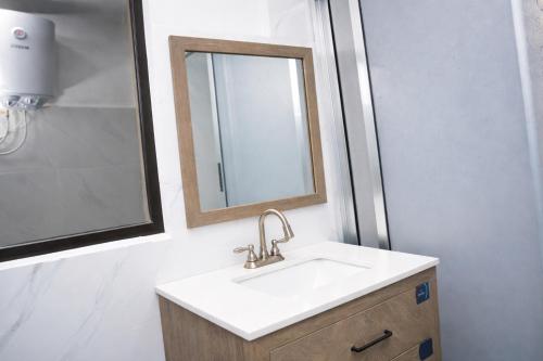 un bagno con lavandino e specchio di Tris Estates Hotel & Suites a Dwarzohn