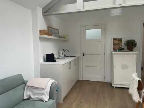 a living room with a couch and a kitchen at Ons Bijhuis in Wijk aan Zee