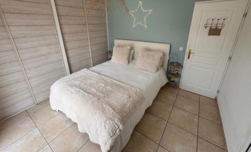 een kleine slaapkamer met een bed met een witte deken bij Villa Entonofa in Nans-les-Pins