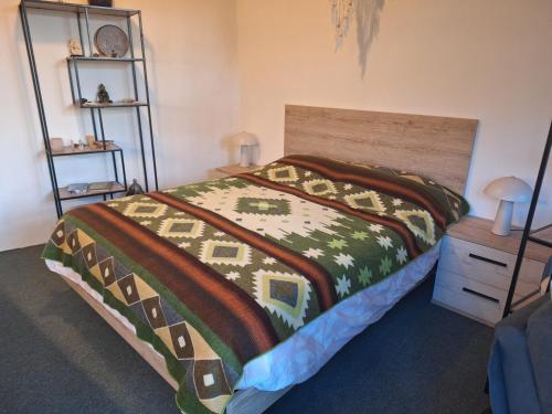 a bedroom with a bed with a colorful blanket at Quinta da Portela in Ferro