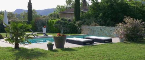 een zwembad met vier comfortabele banken ernaast bij Villa Entonofa in Nans-les-Pins